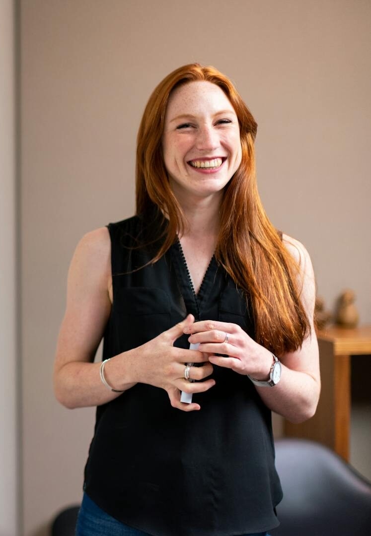 Confident businesswoman smiling during a corporate presentation in a modern office setting.
